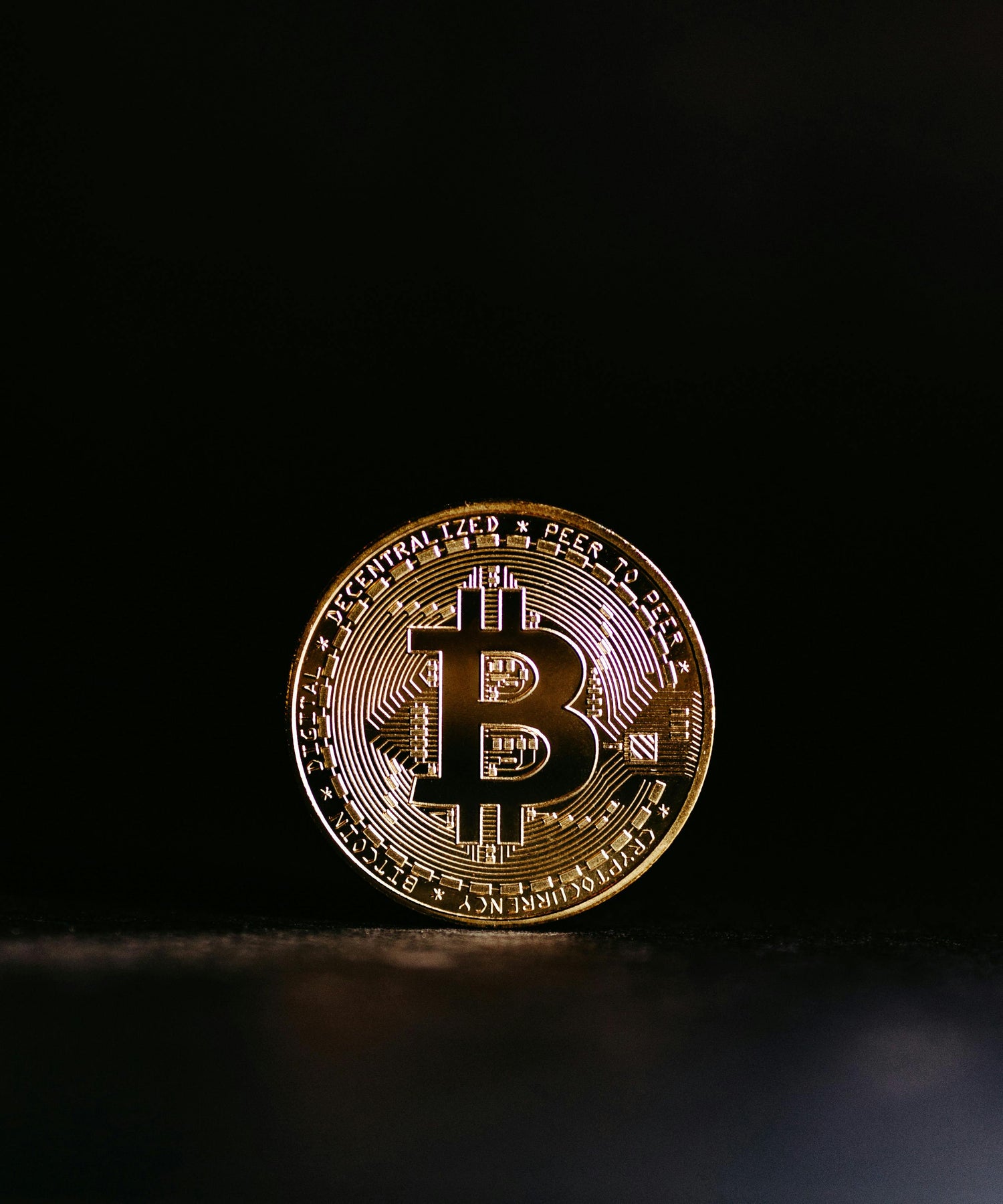 Gold Bitcoin coin on a black background